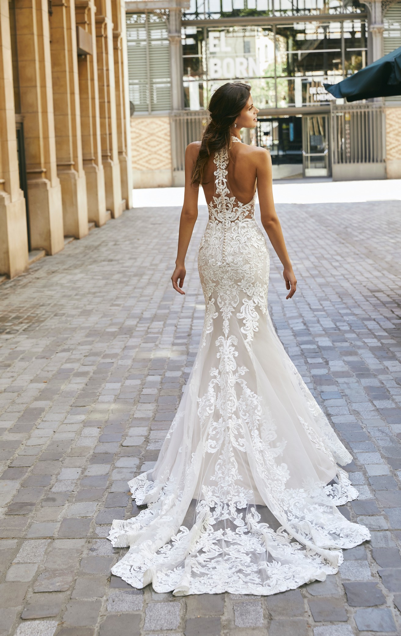 Lady walking in Barcelona neighbourhood wearing fitted fishtail lace and tulle wedding dress with illusion back detail