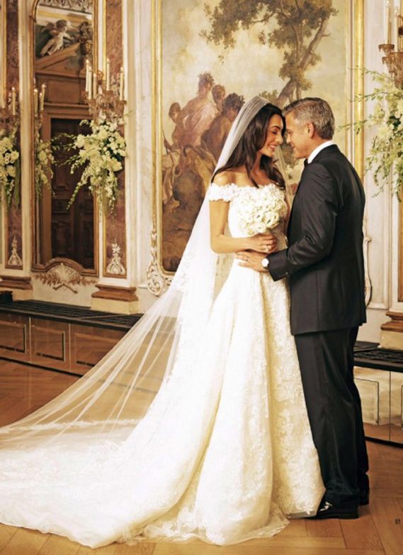 George Clooney and Amal Clooney on wedding day wearing lace fit and flare gown with off the shoulder detail