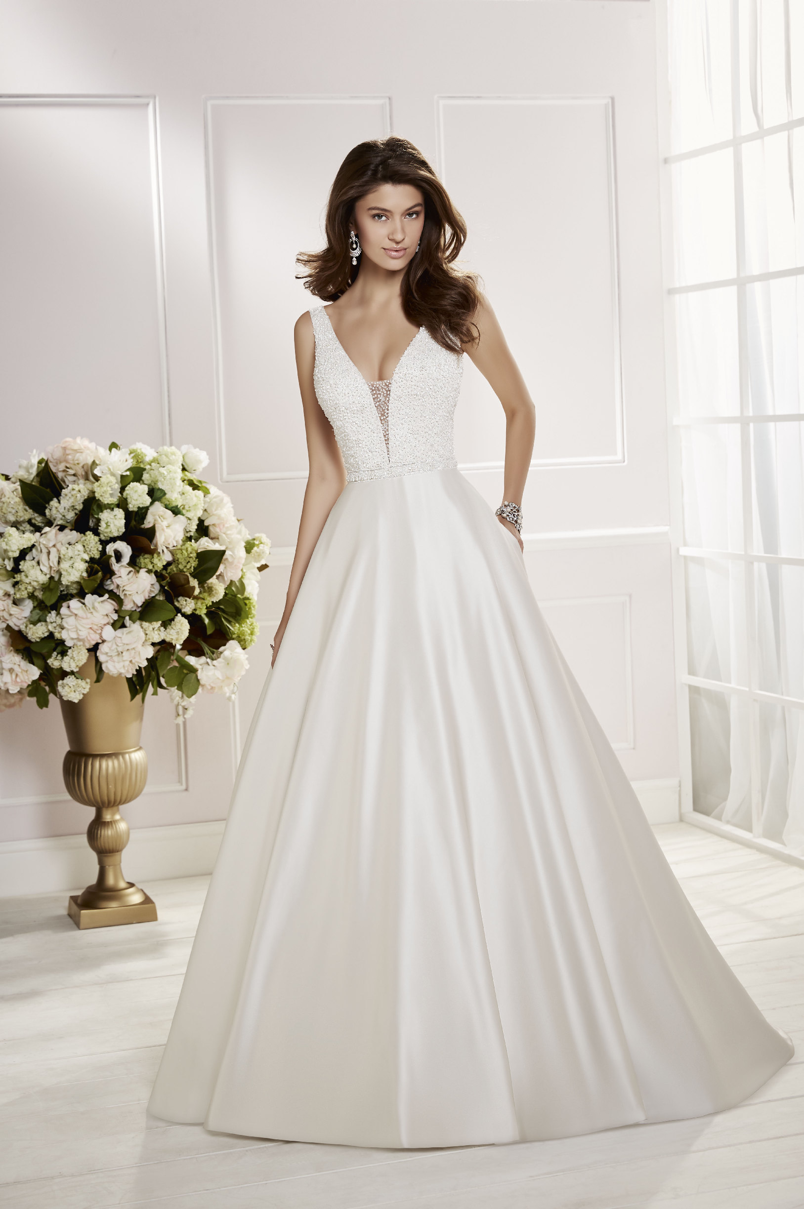 Model wearing Ronald Joyce wedding dress style Cora, 69466, an on-trend ballgown wedding dress with a beaded bodice and contrasting satin skirt  