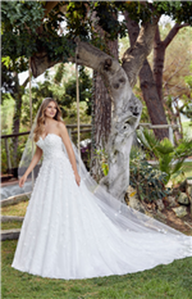 Blonde Woman standing next to tree swing in ballgown wedding dress with 3D floral detail 