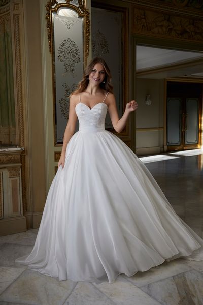 Model stood in a ballroom in Ronald Joyce 69559, a princess ballgown wedding dress with a pearl beaded sweetheart bodice, delicate straps and a ruched waistband 