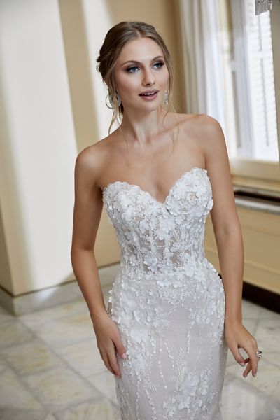 Close up of a model in Ronald Joyce 69566, a popular strapless fit and flare wedding dress with delicate 3D floral appliques, a sheer bodice and sweetheart neckline 