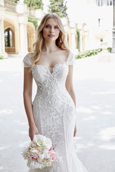 Close up of a model in Ronald Joyce style 69608, a lace and tulle fit and flare wedding gown with a sweetheart neckline and detachable tulle off-the-shoulder short sleeves 