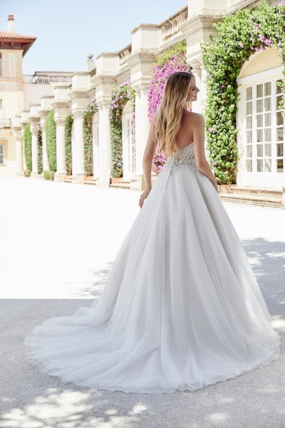 Back of model stood in a floral Italian courtyard in Ronald Joyce style 69612, a vintage inspired ballgown wedding dress with a beaded sweetheart bodice and sparkle tulle skirt
