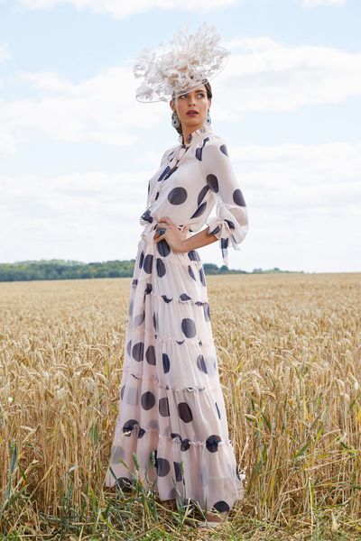 Model stood in a sunny wheat field in Veni Infantino 991760, a long monochrome boho chiffon dress with bold polka dots and long sleeves.