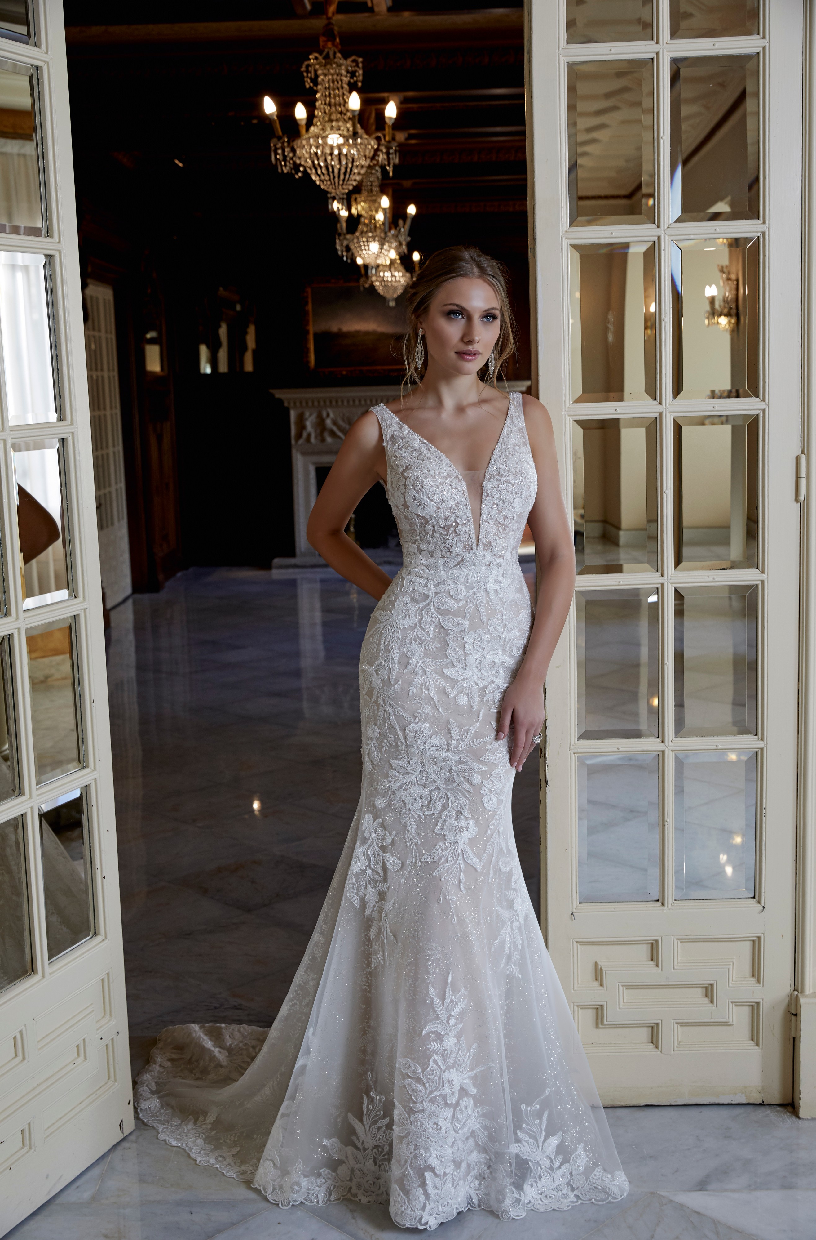 Model wearing one of our Ronald Joyce hot wedding dress trends, Dusty (style 69585) – an ivory lace fit and flare dress with plunging illusion neckline and sparkle detail 