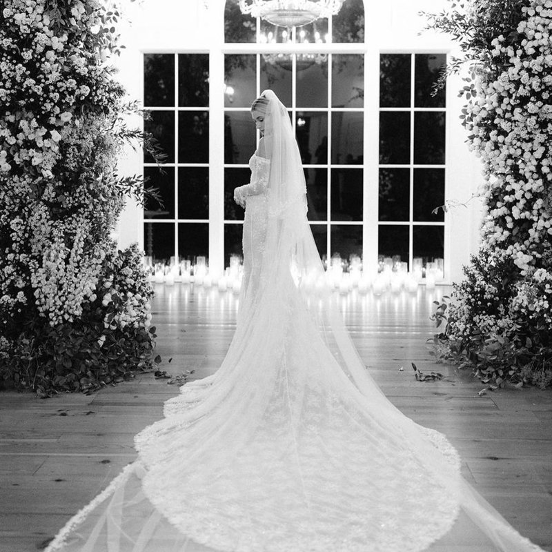 Hailey Bieber on wedding day back image of lace wedding dress with cathedral veil 