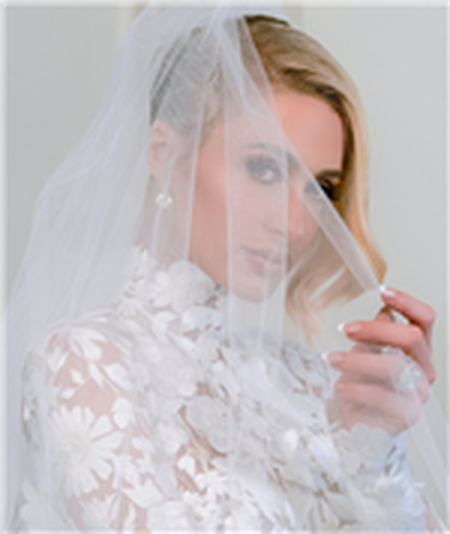 Close up image of Paris Hilton on wedding day wearing floral applique wedding dress and veil