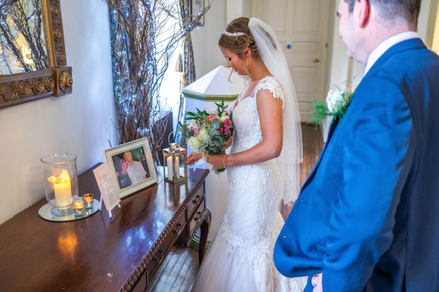 Bride looks at photography and lantern with candle 