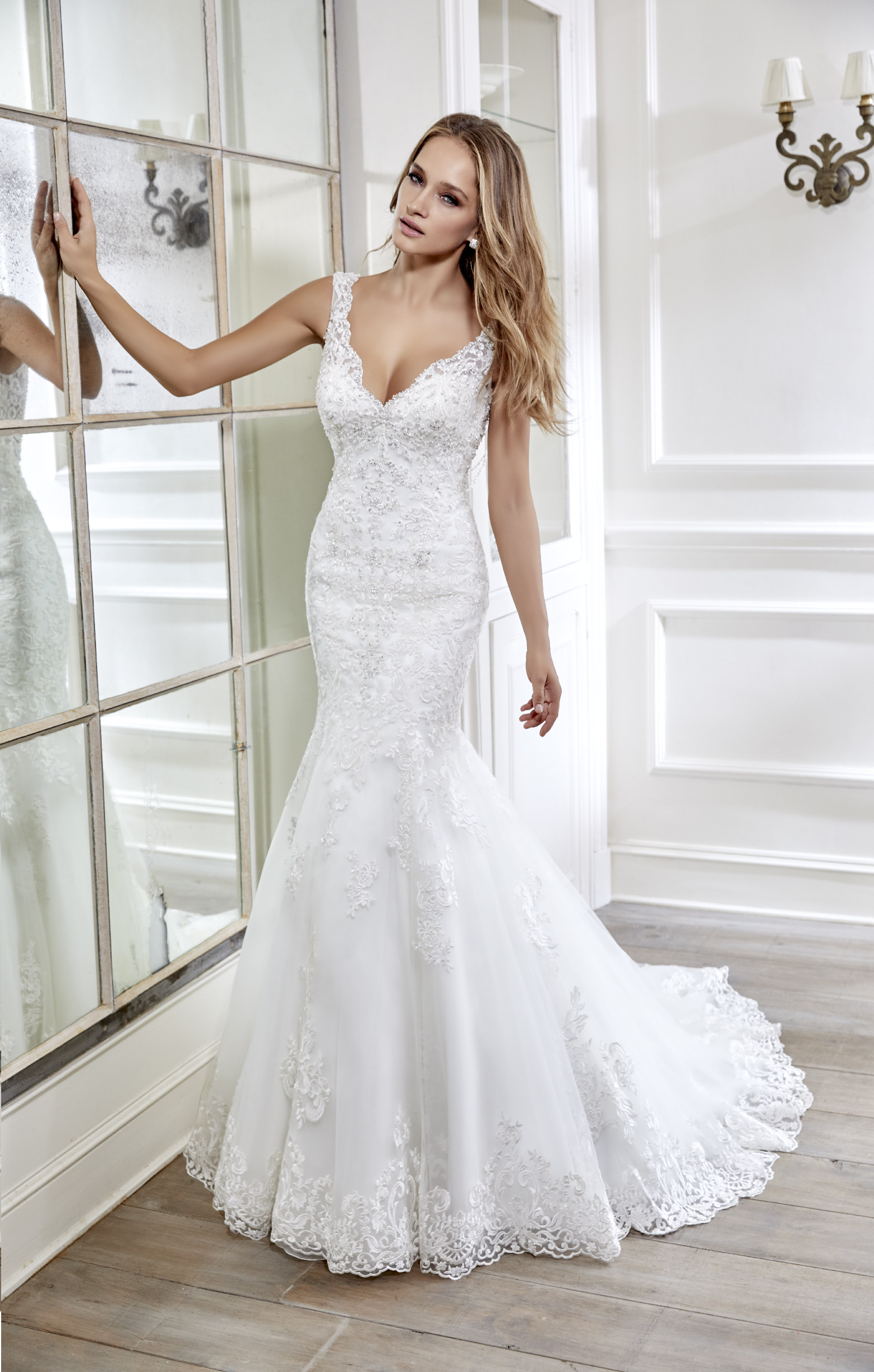 Model wears Ronald Joyce wedding dress style 69009 – a romantic lace fishtail dress with a v-neck that’s perfect for brides who need a wedding dress quickly.