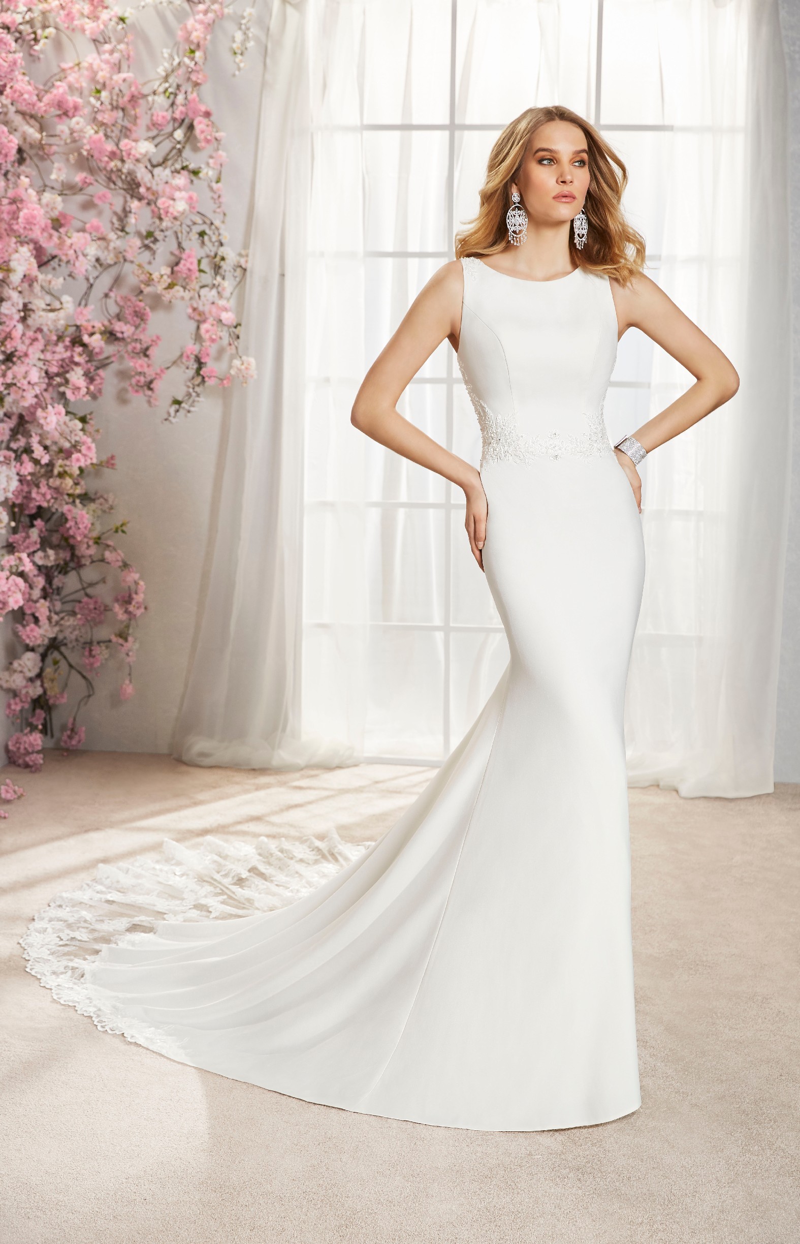 Model wears Ronald Joyce wedding dress style 18364 – a classic fit and flare dress with a high neck that’s perfect for brides who need a wedding dress quickly.