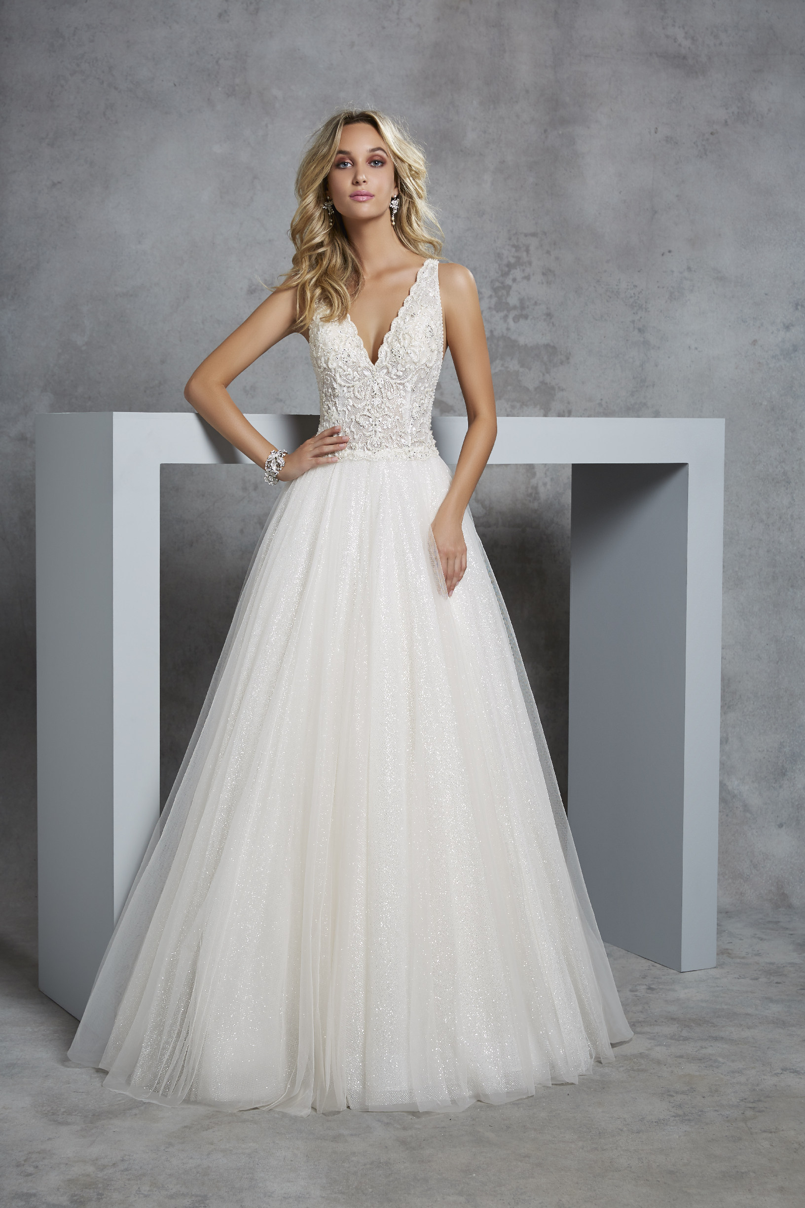 Model wearing Ronald Joyce 69402, an A-line wedding dress silhouette with a scalloped v-neckline, lace bodice and plain glitter tulle skirt.