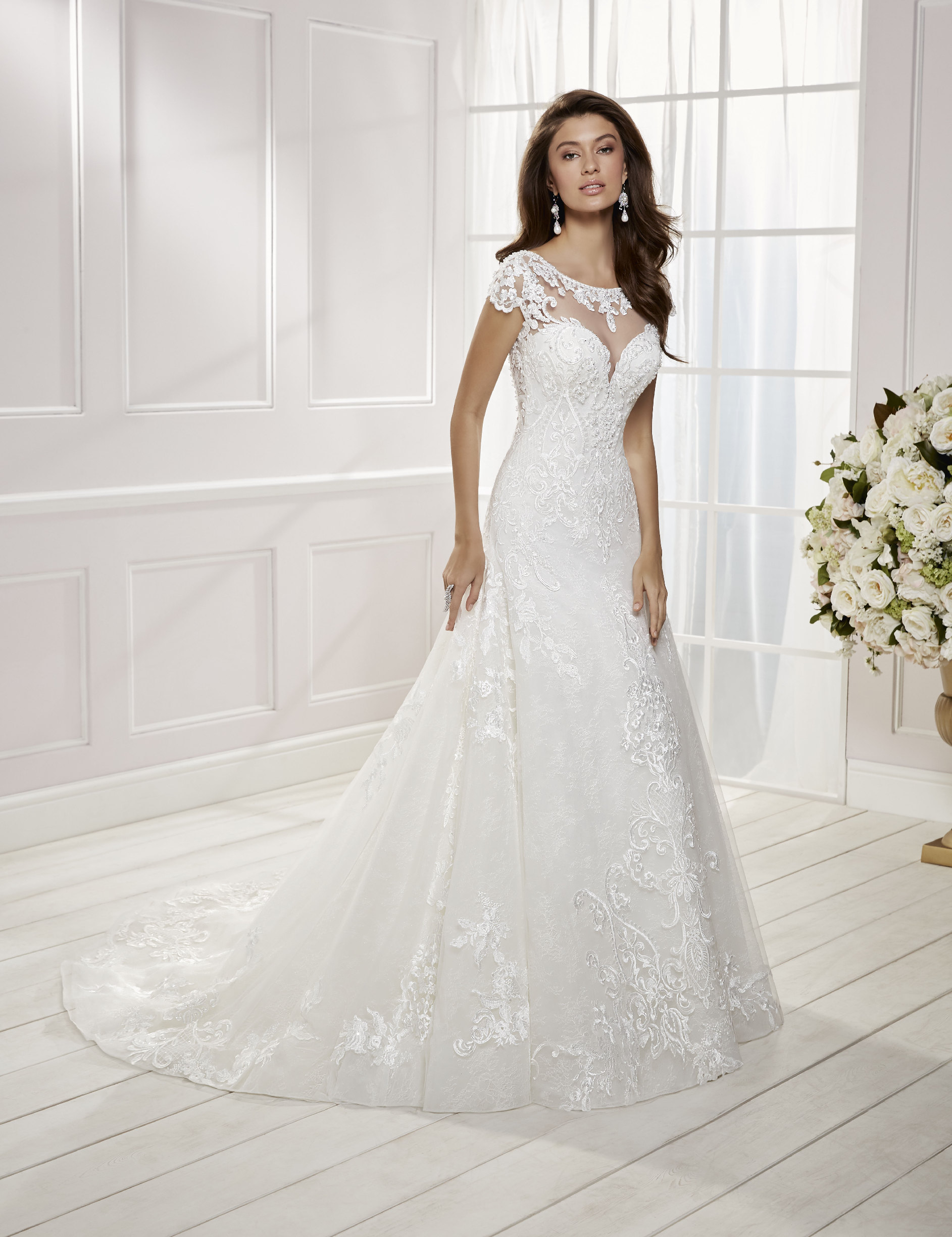 Model in Ronald Joyce wedding dress style 69475 – a lace A-line dress with an illusion sweetheart neckline for brides who need a wedding dress quickly.