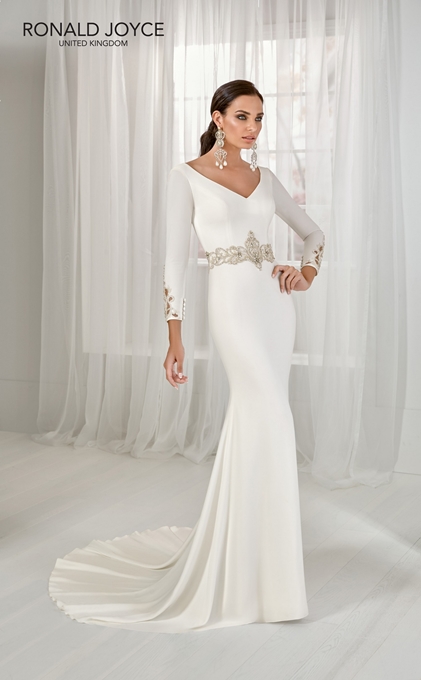Model in Ronald Joyce style 18202, a plain ivory winter wedding dress with a striking embellished waistband, cut out cuff detail, subtle v-neckline and long sleeves